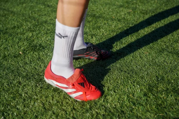 Fußballschuhe und Stutzen auf dem Kunstrasen, bereit für das Training
