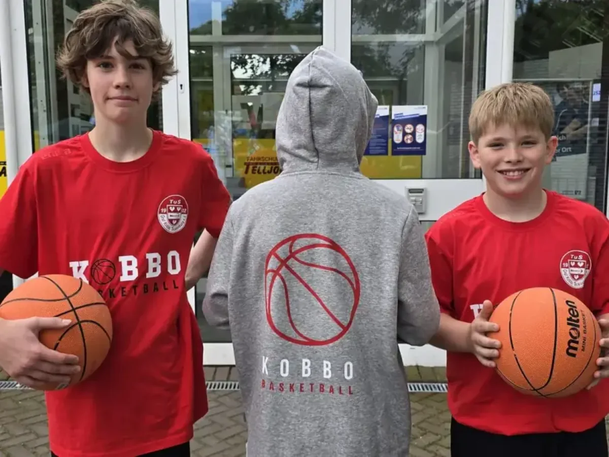 Drei Jugendliche mit Basketbällen und Kobbo-Sportkleidung