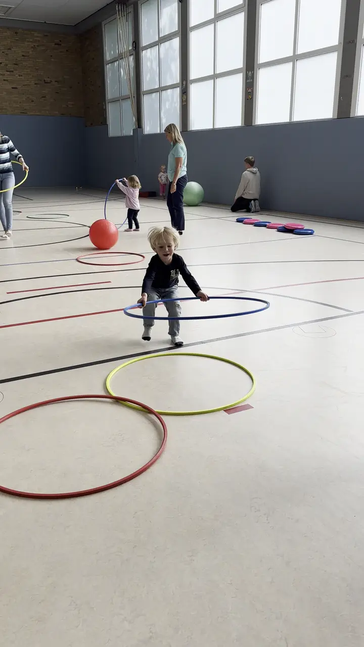 Bunte Kinderturnschuhe stehen aufgereiht auf der Hallenbank